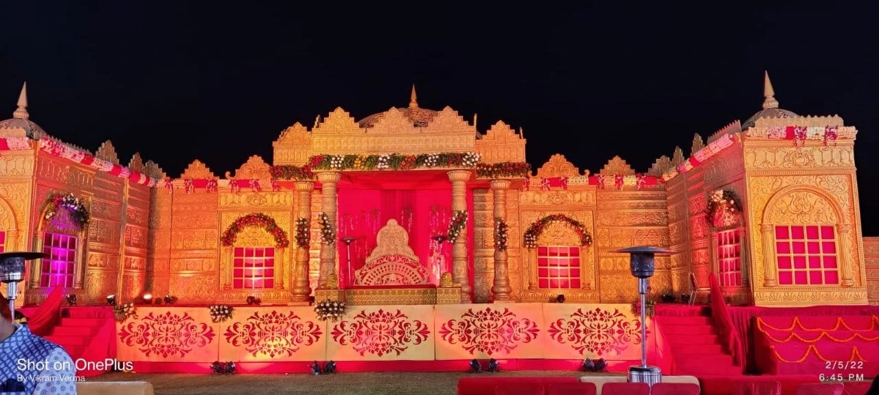 Grand golden wedding stage with pink accents by Prem Tent and Events