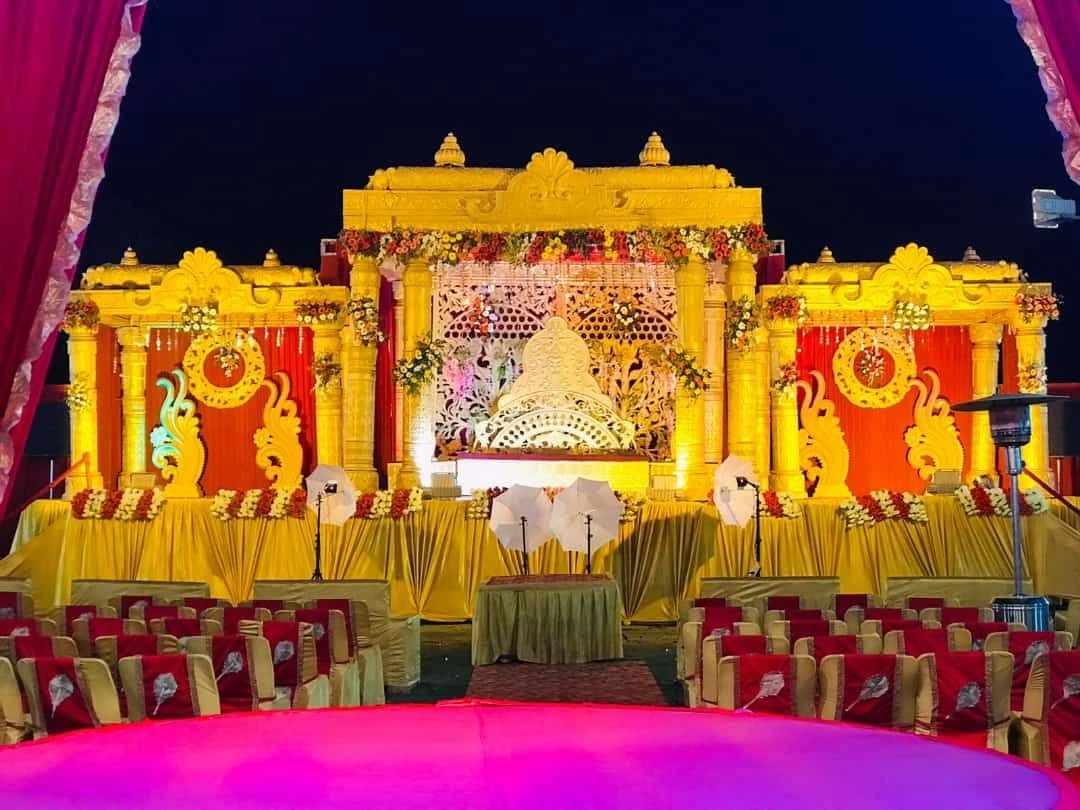 Golden wedding stage with red accents and guest seating